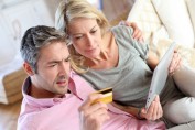 Couple sitting in sofa with electronic tablet